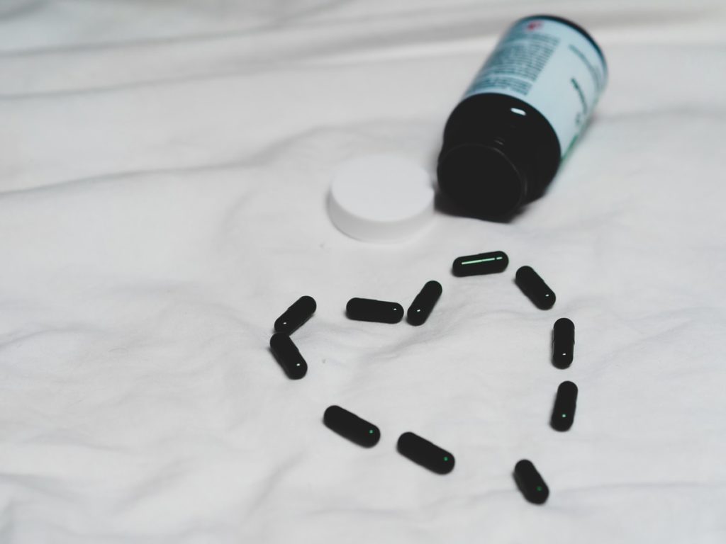 black plastic bottle on white textile